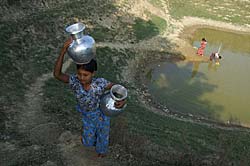 ミャウウーの池から水を運びだす少女。